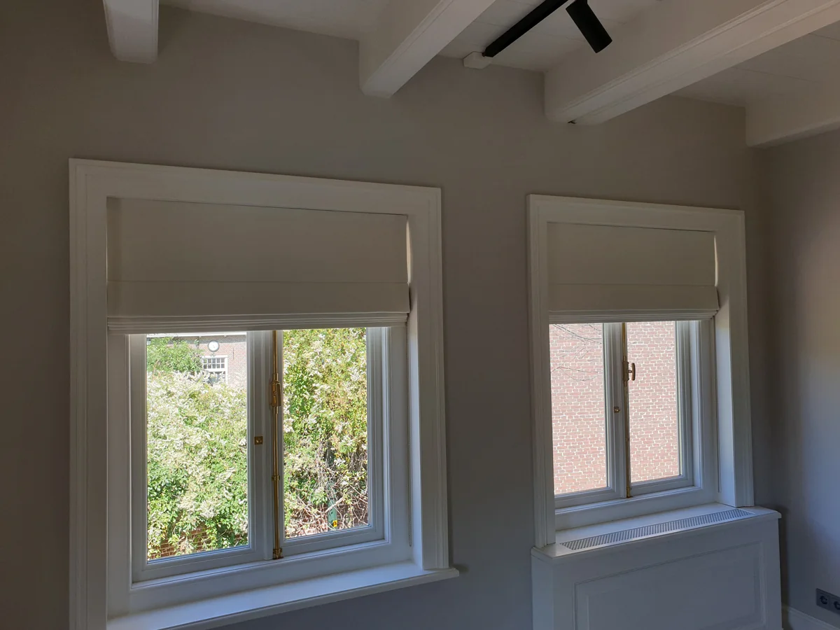 Roomwitte verduisterende vouwgordijnen in een licht interieur